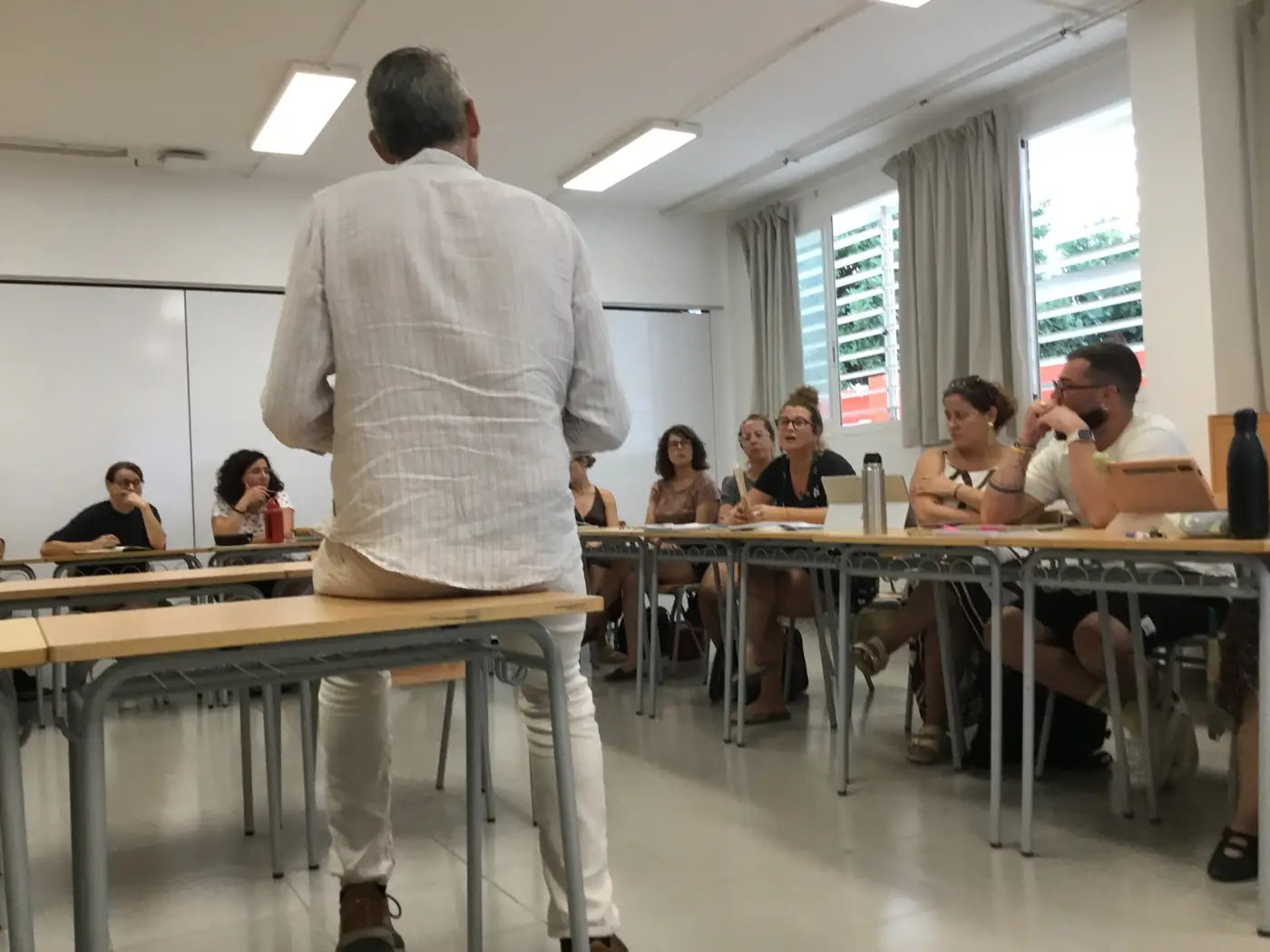 Professorat de l'IES Marc Ferrer escolta la ponència, assegut en taules en forma de U
